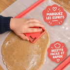 Enfant découpant la pâte avec un emporte-pièce citrouille